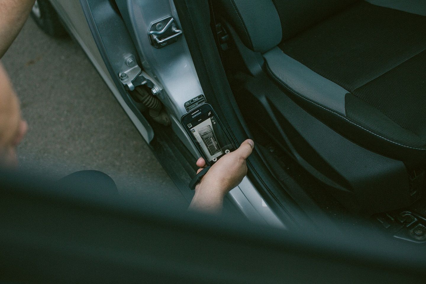 Žmogaus rankos fotografuoja automobilio slenkstį