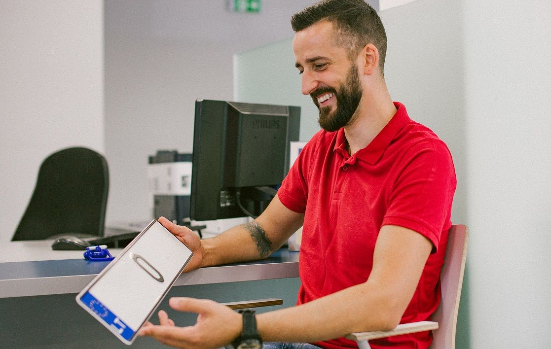 Besišypsantis vyras laiko rankose numerio ženklą "0"