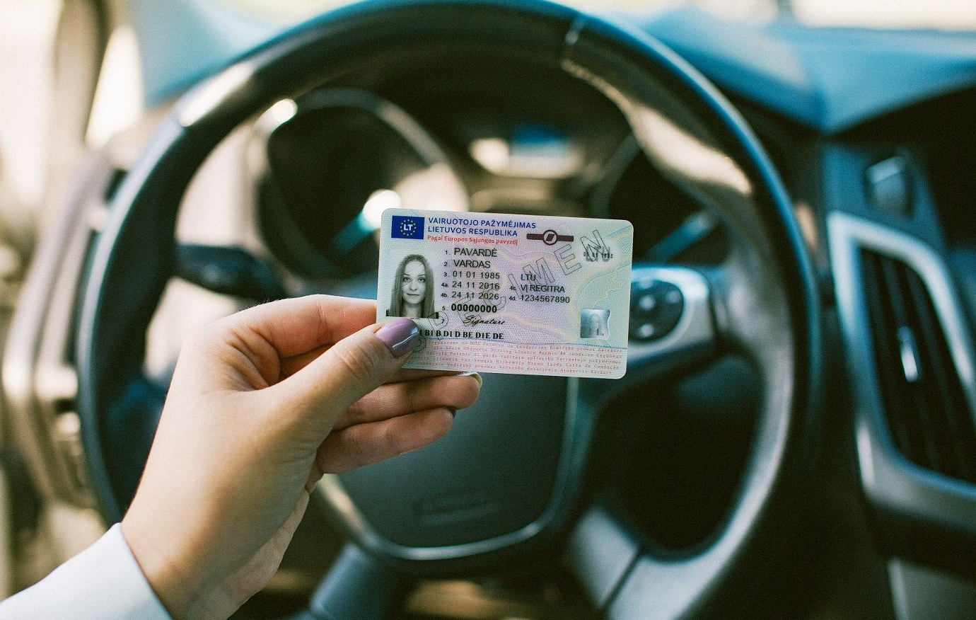 Rankoje laikomas Lietuvos vairuotojo pažymėjimas su matomais asmens duomenų laukais, galiojimo datomis ir vairavimo kategorijomis.