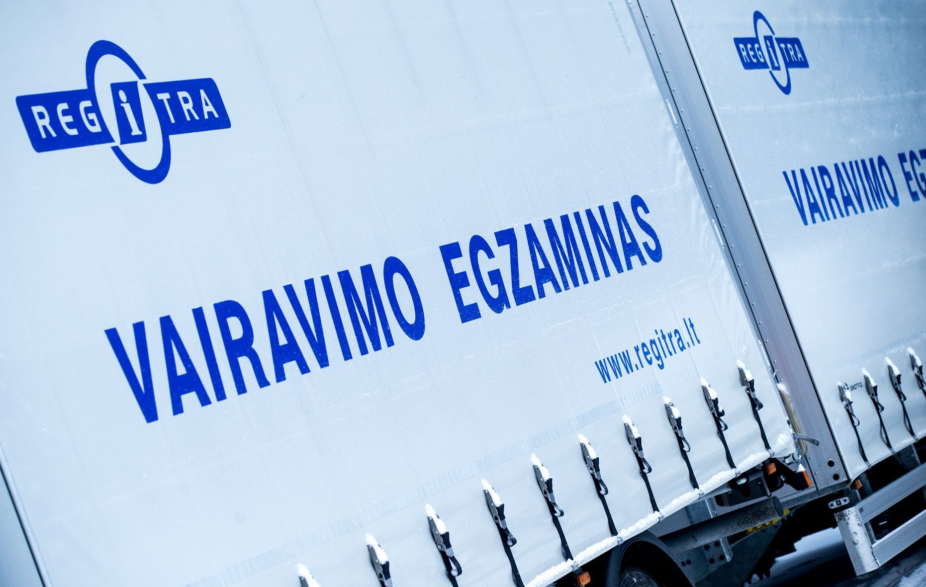 Vilkikas su užrašu "Vairavimo egzaminas" ir Regitros logotipas