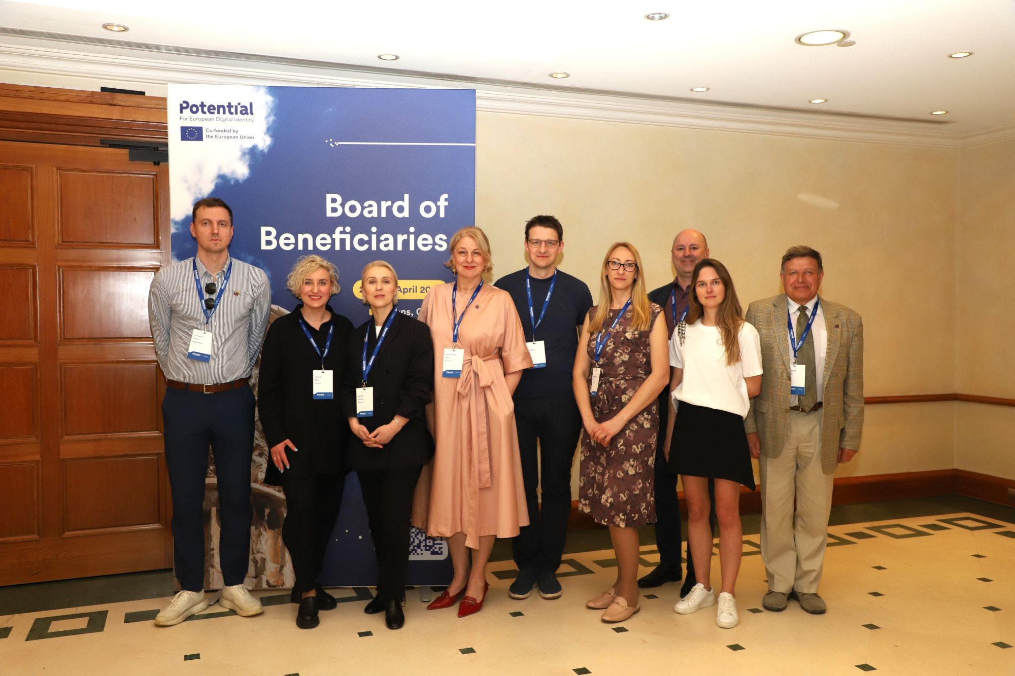 Penktoje nuotraukoje matoma devynių žmonių grupė, stovinti priešais plakatą su užrašu „Board of Beneficiaries“. Plakate taip pat yra „Potential“ logotipas ir Europos Sąjungos vėliava, kas rodo, jog tai susiję su ES finansuojamu projektu ar iniciatyva.
