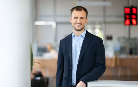 Vyras su kostiumu ir mėlynais marškiniais