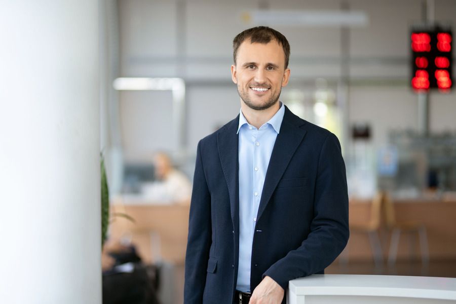 Vyras su kostiumu ir mėlynais marškiniais