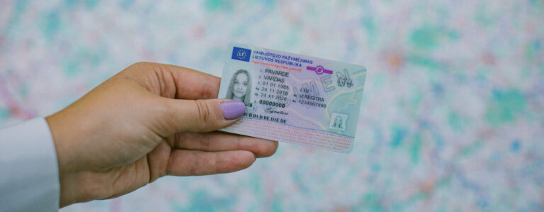 Rankoje laikomas Lietuvos vairuotojo pažymėjimas su matomais asmens duomenų laukais, galiojimo datomis ir vairavimo kategorijomis.