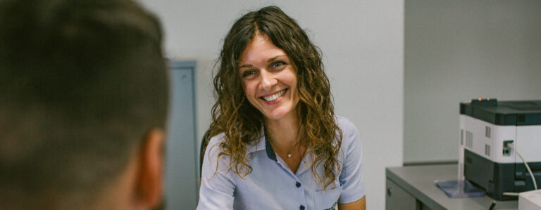 Besišypsanti moteris garbanotais plaukais