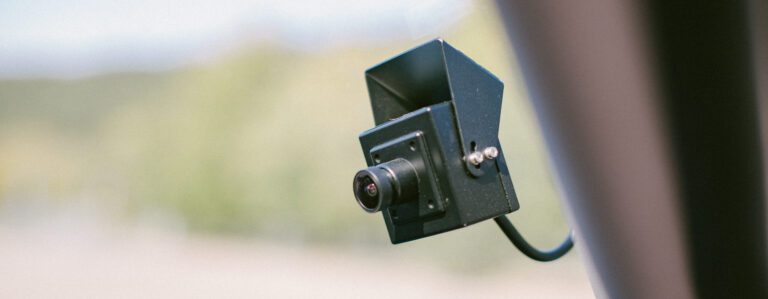 Juoda stebėjimo kamera, pritvirtinta prie paviršiaus, nukreipta žemyn