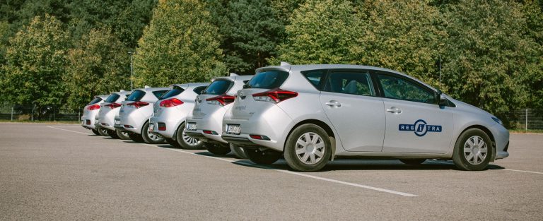 „Regitros“ automobiliai išrikiuoti lauke prie medžių