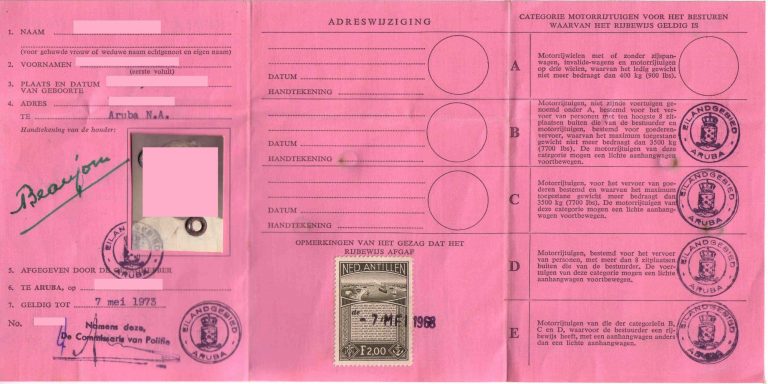 Rožinis dokumentas iš Arubos su užpildytomis sekcijomis olandų kalba, asmens duomenimis, spaudais ir pašto ženklu.