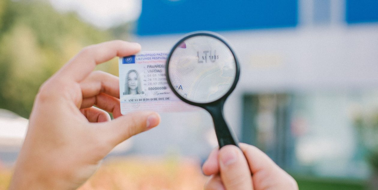 Didinamasis stiklas virš vairuotojo pažymėjimo su tekstu „LTU“