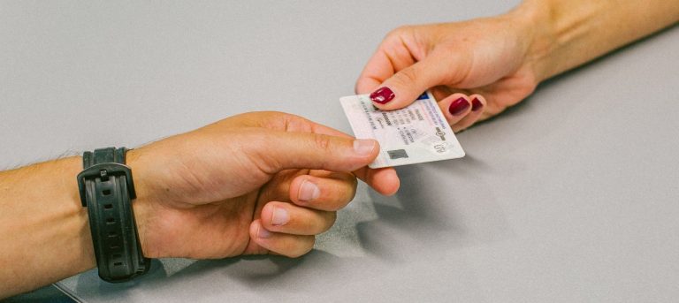 Du žmonės perduoda vienas kitam vairuotojo pažymėjimą