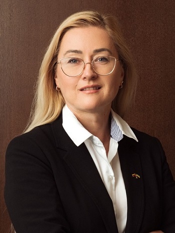 Moteris su akiniais ir ilgais šviesiais plaukai su marškiniais ir švarku