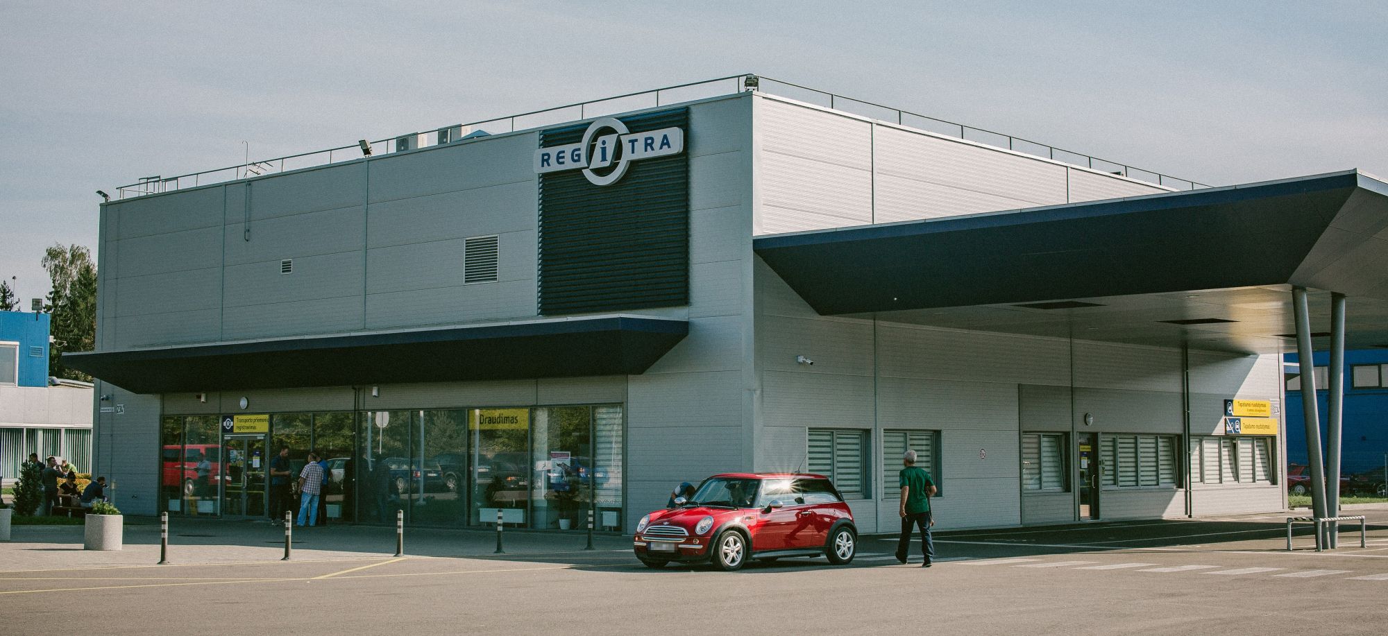 Regitros padalinys ir raudonas automobilis prie jo