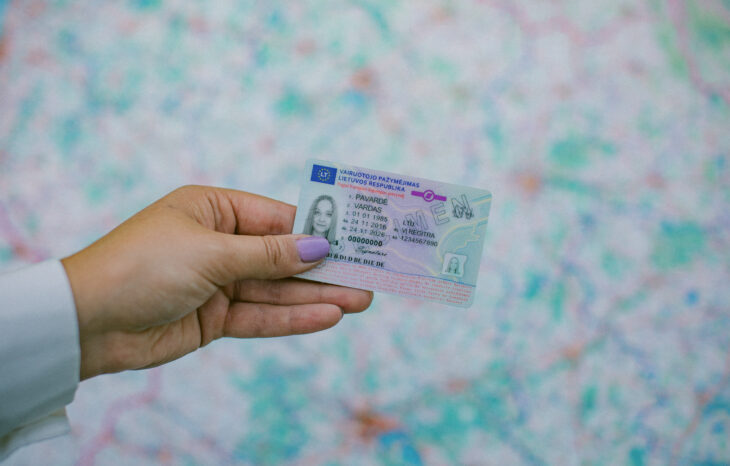 Rankoje laikomas Lietuvos vairuotojo pažymėjimas su matomais asmens duomenų laukais ir galiojimo datomis.