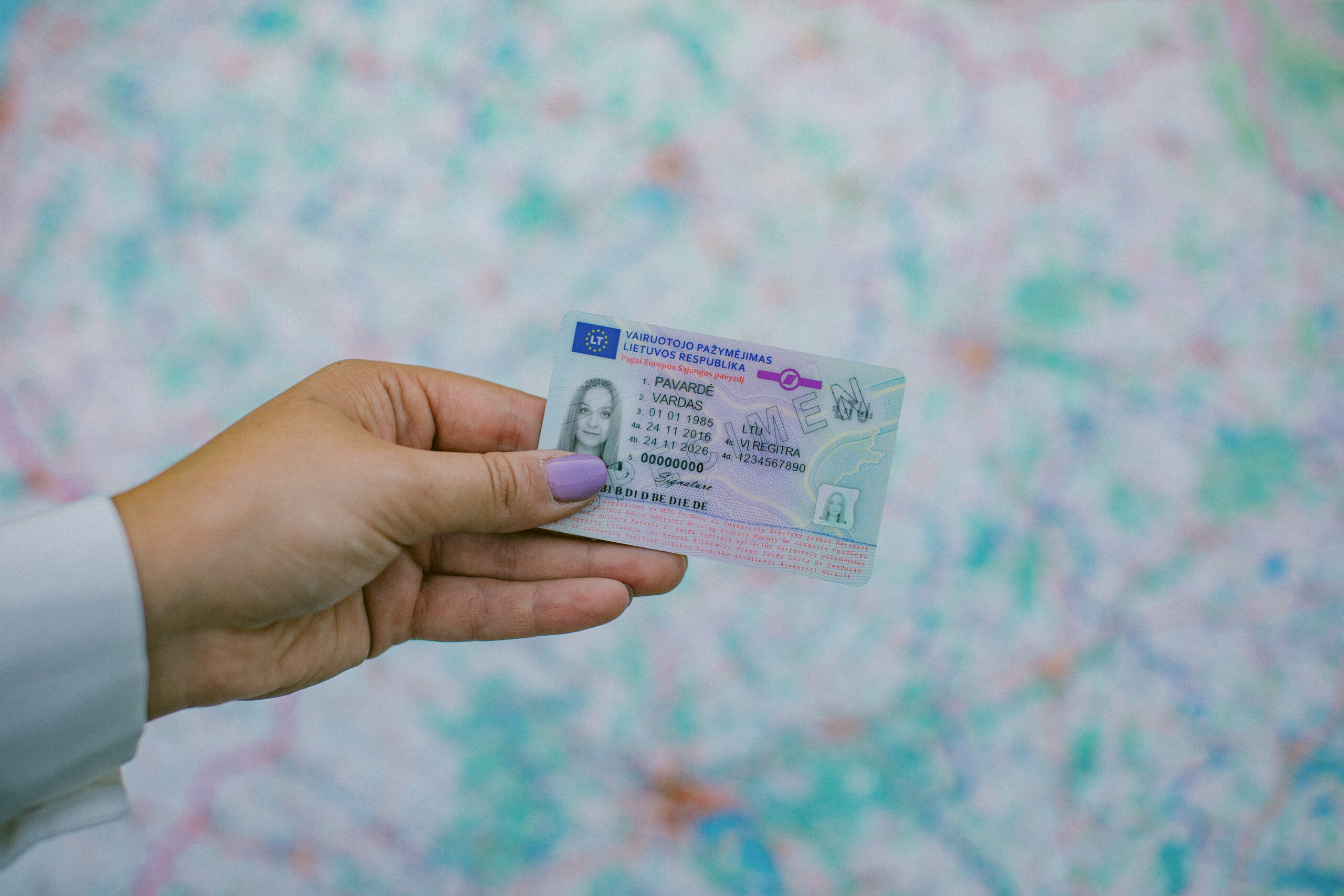 Rankoje laikomas Lietuvos vairuotojo pažymėjimas su matomais asmens duomenų laukais ir galiojimo datomis.