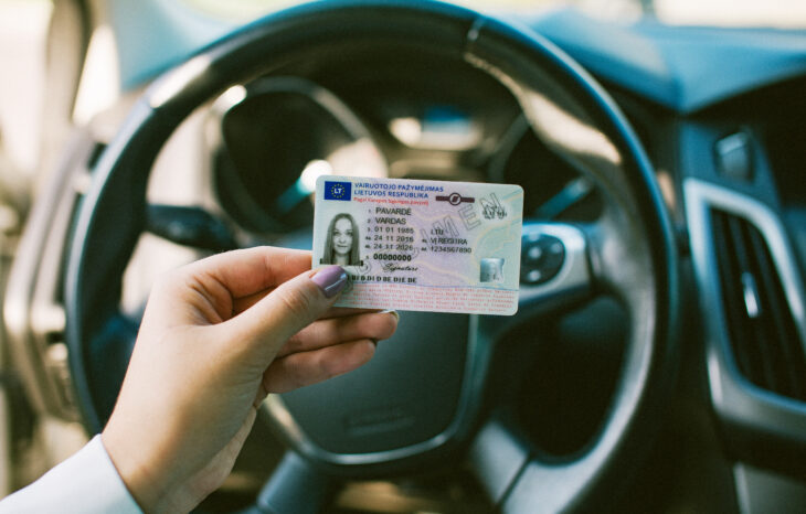 Rankoje laikomas Lietuvos vairuotojo pažymėjimas su matomais asmens duomenų laukais, galiojimo datomis ir vairavimo kategorijomis.