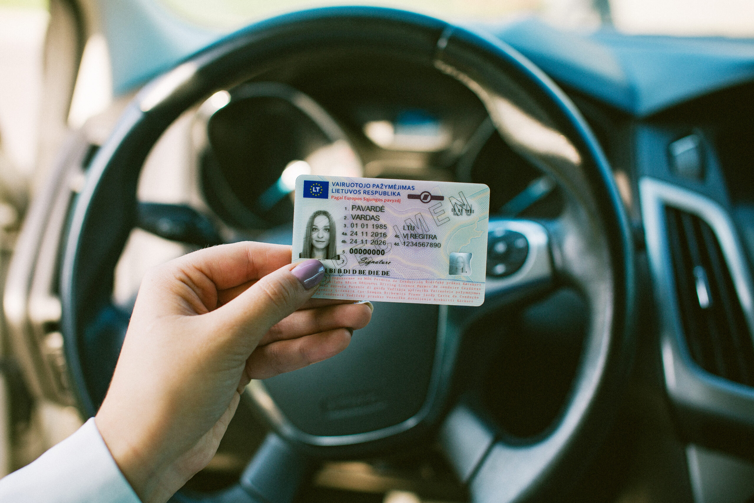 Rankoje laikomas Lietuvos vairuotojo pažymėjimas su matomais asmens duomenų laukais, galiojimo datomis ir vairavimo kategorijomis.