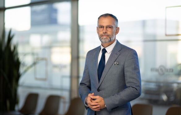 vyras su kostiumu, akiniais ir kaklaraiščiu