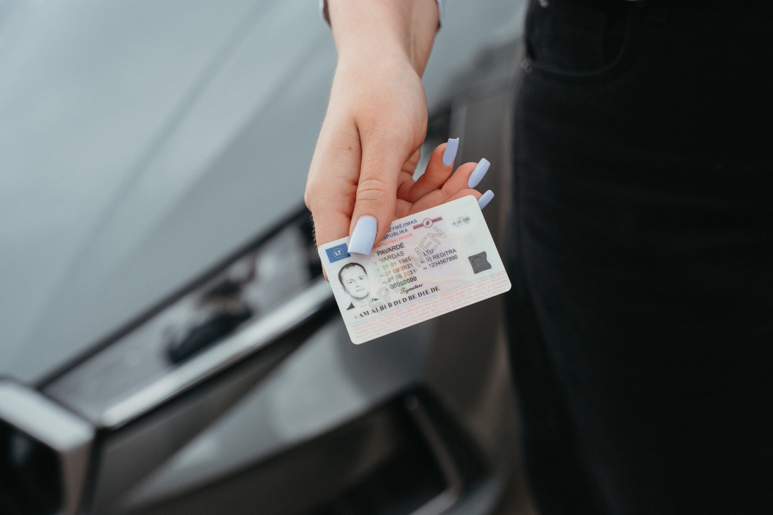 Vairuotojo pažymėjimas rankoje